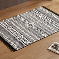 Black And White Square Carpet With Geometric Pattern And Fringed Edges On Wooden Floor