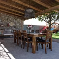 Garden Landscape with Wooden Roof Stone Wall Patio Dining Area Playground and Sunlit Lawn
