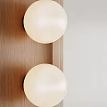 White Spherical Wall Lamps Mounted on Wooden Background Wall with Light Colored Wall Beside