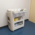 White Medical Cart With Storage Shelves Holding Medical Supplies In Hospital Room