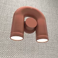 Modern Rose Gold Wall Lamp With U Shaped Design And Circular Element On Fabric Background