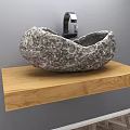 Natural Stone Rock Washbasin On Wooden Countertop With Black Faucet And Gray Wall