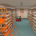 Spacious Warehouse Interior With Organized Metal Shelves Red Forklift Orange Ladder And Storage Boxes