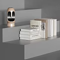 Gray Stepped Shelf Display With Various White Beige Books And Golden Humanoid Head Sculpture