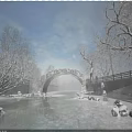 Stone Arch Bridge With Snow Covered Trees Frozen River Sunlight And Blue Sky
