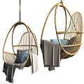 Stylish Rattan Hanging Chair with Blue and Gray Pillows and Cozy Blanket