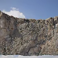 Majestic Cliff With Rocky Surface Under Blue Sky And White Clouds