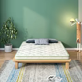 Comfortable Quilted Mattress On Wooden Frame With Grey Pillows Green Wall And Indoor Plant