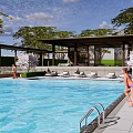 Outdoor Pergola By Swimming Pool With Loungers Trees And People Relaxing
