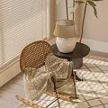 Rattan Leisure Chair with Patterned Blanket Beside Small Round Table and Lamp in Sunlit Room