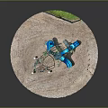 Playground Equipment In Circular Sandy Area With Blue Slide And Green Climbing Structure