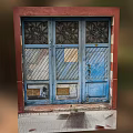 Weathered Blue Entrance Door With Decorative Patterns Striped Panels Bronze Plates And Red Frame