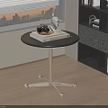 Round Black Top Side Table with Silver Metal Base Wheels and Decorative Items Near Bookshelf