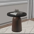 Round Side Table With Black Top Brown Wooden Base Holding Silver Coffee Cup And Book