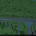 Elevated Bridge With Evening Lights Over River In Green Mountain Forest With Concrete Piers