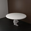 Round White Dining Table With Unique Twisted Base Against Dark Wooden Wall And Black Floor