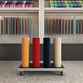 Colorful Fabric Rolls Display On Cart With Shelves In Showroom Interior