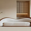 Modern Three Seater Sofa With White Upholstery Curved Brown Frame And Potted Plant Floor Lamp