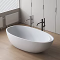 Freestanding White Oval Bathtub With Black Silver Faucets Wooden Floor And White Cabinets