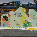 Spring Photo Check-in Spot With Cartoon Girl Arch Design Flower Decorations And Modern Buildings