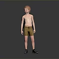 Red Haired Boy In Green T Shirt Yellow Shorts And Black Shoes Against Grey Background