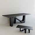 Black Modern Desk with Unique Geometric Legs and Small Bench in Light Colored Room