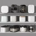 Modern Kitchen Appliances With Various Designs And Colors Displayed On White Shelves