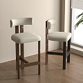 Two Modern Bar Stools With Upholstered Seats Wooden Legs By Window And Plant