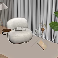 Cozy Living Room Corner With Beige Curved Armchair Small Coffee Table And Green Plant