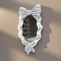 White Decorative Mirror with Bow Shaped Frame Wavy Edges on Light Brown Wall with Shadows