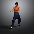 Man Performing Martial Arts Action In Black Vest And Blue Pants Against Gray Background
