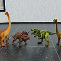 Colorful Dinosaur Toys Various Species On Dark Spotted Floor With Leaf Pattern Wallpaper