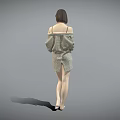 Woman in Plaid Cardigan and Shorts Standing Barefoot Against Gray Background with Hands on Outfit