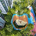 Colorful Children's Play Area With Sandpit Slides Lush Trees And High Rise Buildings