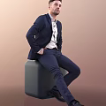 Man In Navy Blue Suit And White Shirt Sitting On Gray Cube With Brown Background