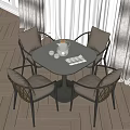 Round Dining Table With Four Woven Chairs And Beige Cushions In Cozy Interior
