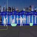 Surfing Themed Illuminated Wave Structure With People Taking Photos In Urban Night View