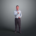 Man in light blue shirt and dark pants gesturing with right fist against gray background