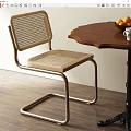Modern Woven Dining Chair With Metal Frame And Wooden Table With Oranges