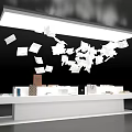 White Display Table With Items And Flying Papers Under Overhead Lighting On Black Background