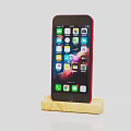 Red Mobile Phone Placed on Wooden Stand with Screen Showing Multiple App Icons