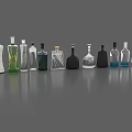 Various Colored Wine Bottles and Glasses with Different Shapes Arranged on Gray Surface