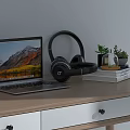 Modern Laptop With Scenic Screen On Wooden Desk With Black Headphones Books And Potted Plants