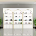 Perfume Cosmetics Display On White Arched Shelves With Gold Trim And Green Plants