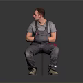 Man Sitting On Chair In Gray T Shirt And Gray Overalls With Red Details Beige Shoes On Gray Gradient Background