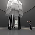 White Layered Art Installation With Black Pillars In Modern Gallery Space