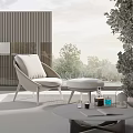 Round Outdoor Table With Wicker Chair Cushioned Seat Plants And Books Near Trees
