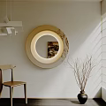 Lighted Round Mirror on White Wall with Wooden Chair Black Vase and Natural Light