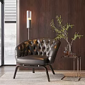 Tufted Black Leather Lounge Chair with Floor Lamp Side Table Green Plant and Wooden Wall