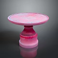 Pink Round Pedestal Table With Modern Smooth Surface And Decorative Base